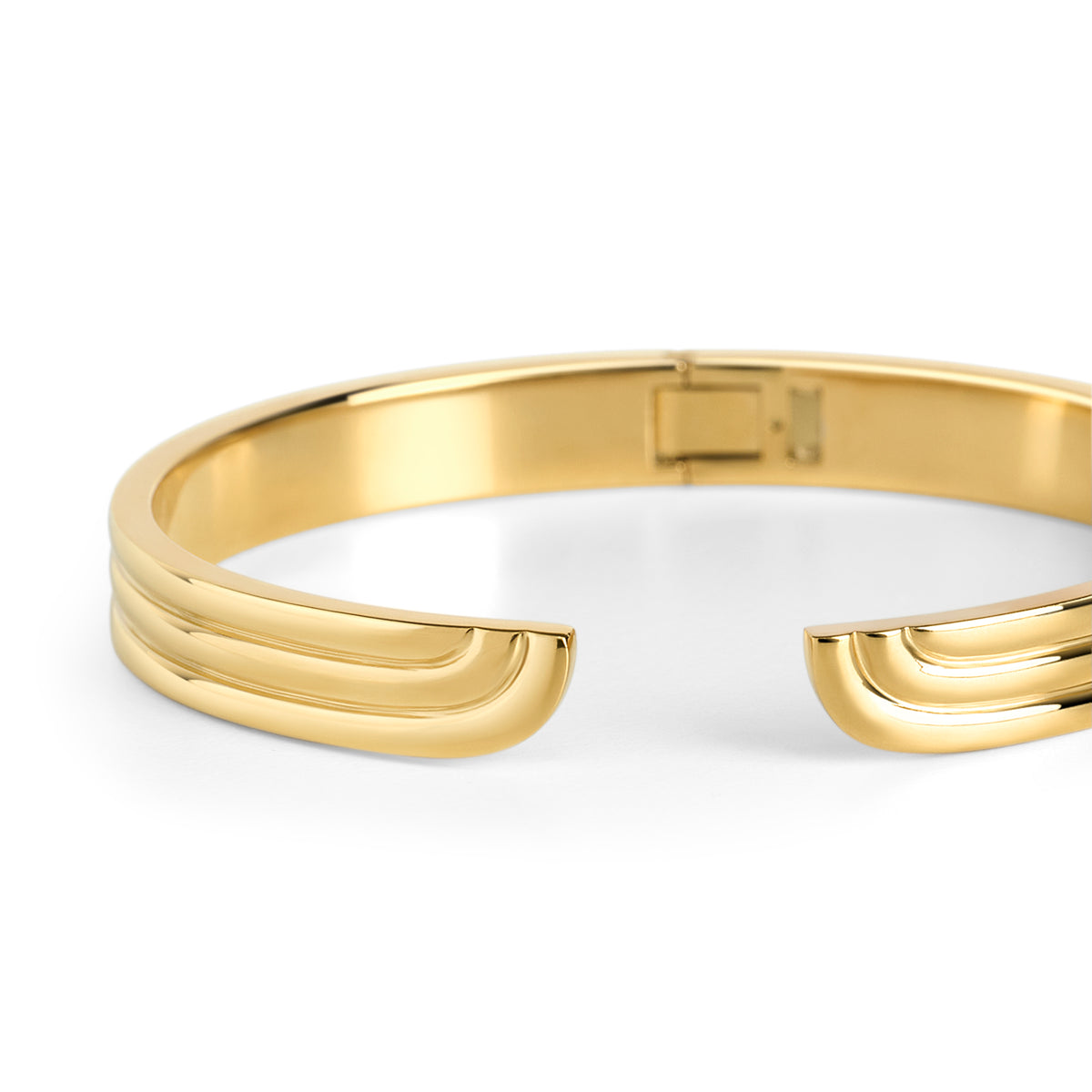 Front view of an open gold bangle bracelet with grooved wave-shaped ends on a white background. Waterproof, stainless steel and allergy free. By Mia Bijoux Canada.
Vue de face d'un bracelet jonc ouvert doré aux extrémités rainurées en forme de vagues sur fond blanc. Résistant à l'eau, en acier inoxydable et hypoallergénique. Par Mia Bijoux Canada.
