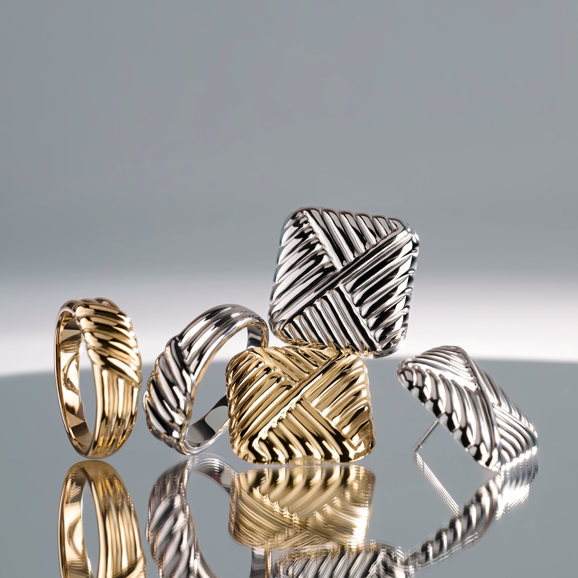 Gold and silver stainless steel textured jewelry set with sculptural rings and stud earrings, woven modern design, hypoallergenic non-tarnish durable jewelry, bold contemporary fashion jewelry.

